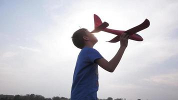 Male boy play with toy airplane in summer fields video