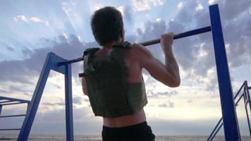 Entrenamiento joven atleta barbudo al aire libre con chaleco lastrado video