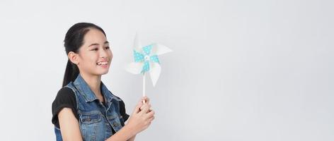 Teenage woman and paper windmill toys. teen with wind wheel stick photo