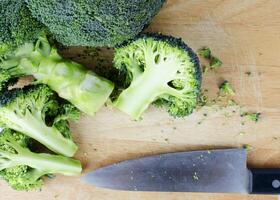 Broccoli sliced on wooden cutting board photo