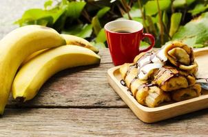 Banana tostada francesa y bebidas de café sobre fondos de mesa de madera foto