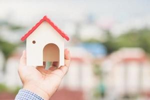 Hand holding mockup house. Real estate loan insurance photo