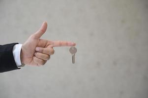 cerrar la mano de negocios sosteniendo la llave en casa. foto