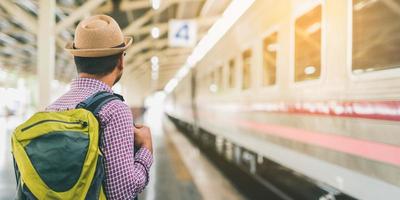 Young traveler man at platform train station. Traveling concept. photo