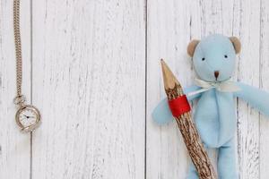 White painted wood table blue bear doll holding pencil pocket clock photo