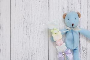 white painted wood table blue bear doll holding cotton candy photo