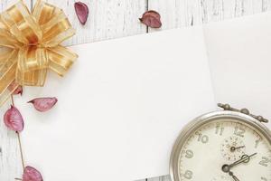 Paper mock-up with clock, petals, and bow photo