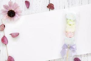 Paper with candy and flower photo