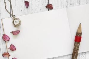 Paper with watch, petals, and pencil photo