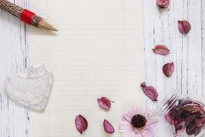 Paper with flower, pencil and heart photo