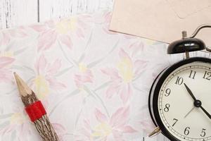 Floral paper with a pencil and clock photo