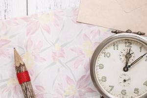 Floral paper with a pencil and clock photo