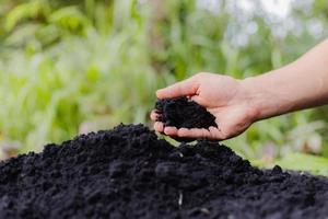 Farmer's hands plow the soil to prepare for planting. photo