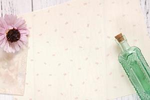 Paper with flower and bottle photo