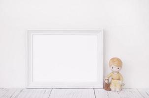 White frame with ceramic doll
