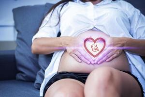 Pregnant woman with baby illustration in heart shape photo