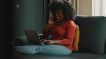 mulher sentada no sofá com laptop terminando a ligação video