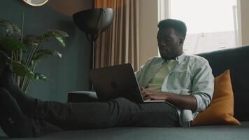 Man sitting on couch with laptop having video call
