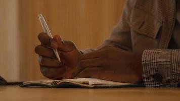 Close up of man talking seriously sitting at table holding pen video