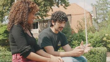 Man holds smartphone and talks about it with woman in front yard video