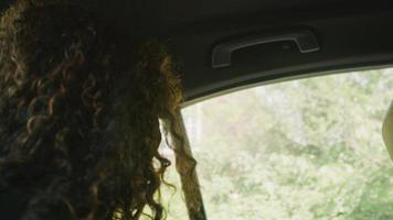 une femme assise à l'arrière de la cabine descend de la voiture et ferme la porte video