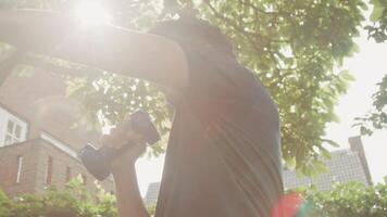 Man standing in garden making boxing movements with dumbbells video