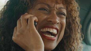 Close up of woman sitting in back of car talking on smartphone video