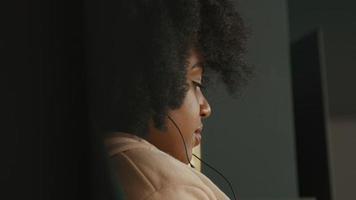 Woman with earphones sitting and moving on music video