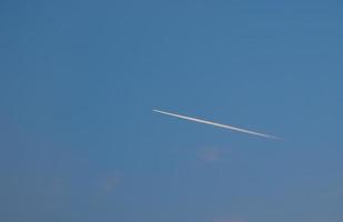 Plane trail over blue sky photo