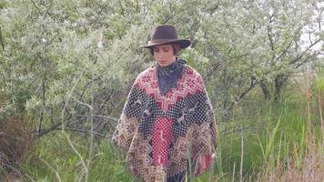 Young woman traveler in poncho and hat walk in the fields and farm video