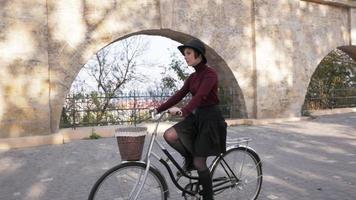 mujer joven, equitación, en, retro, bicicleta, en, el, otoño, parque video