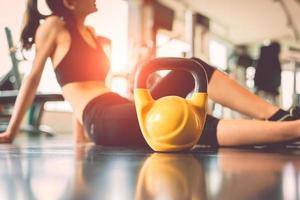 Close up kettlebells with woman exercise workout in gym photo