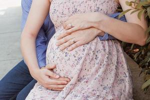 una futura madre y un padre sosteniendo su estómago foto