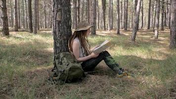 giovane donna viaggiatrice nella foresta con mappa in mano video