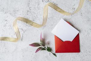 A blank card with red envelope and leaf is placed on white background