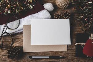 Envelope, blank card, glasses and a pen is placed on wood. photo