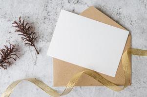 A blank card with envelope and leaf is placed on white background photo