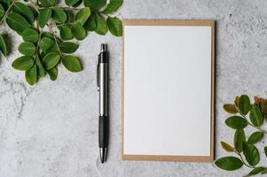 A blank card with envelope, pen and leaf is placed on white background photo