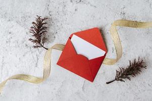 A blank card with red envelope and leaf is placed on white background photo