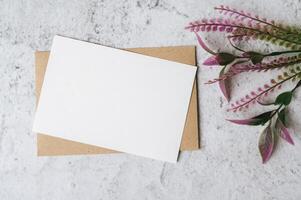 A blank card with envelope and flower is placed on white background photo