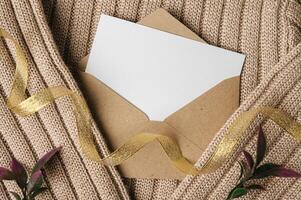 A blank card is placed on envelope and a sweater photo
