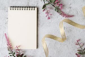 notebook, pen and flower is placed on white background photo