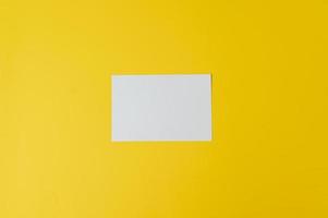 A blank card is placed on yellow background photo