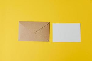 A blank card with envelope is placed on yellow background photo