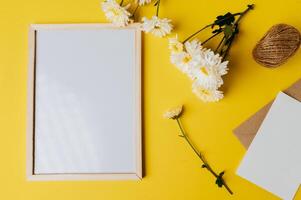 White board with envelope and flower is placed on yellow background photo