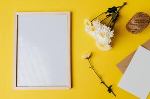 White board with envelope and flower is placed on yellow background photo