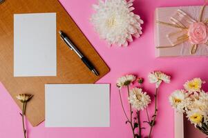 pink gift box, flower, pen, wood board and blank card on pink photo