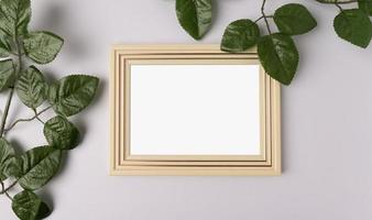 white photo frame and leaf branches on white background