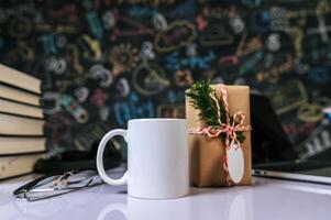 la taza y la caja de regalo en la mesa del aula. foto