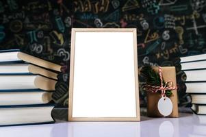 white photo frame, book and colored pencils in classroom